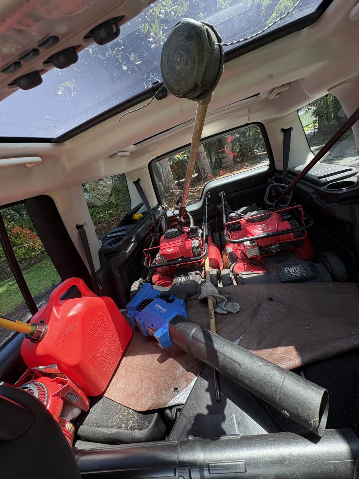 Early Lawn Lads equipment loaded into the back of a car