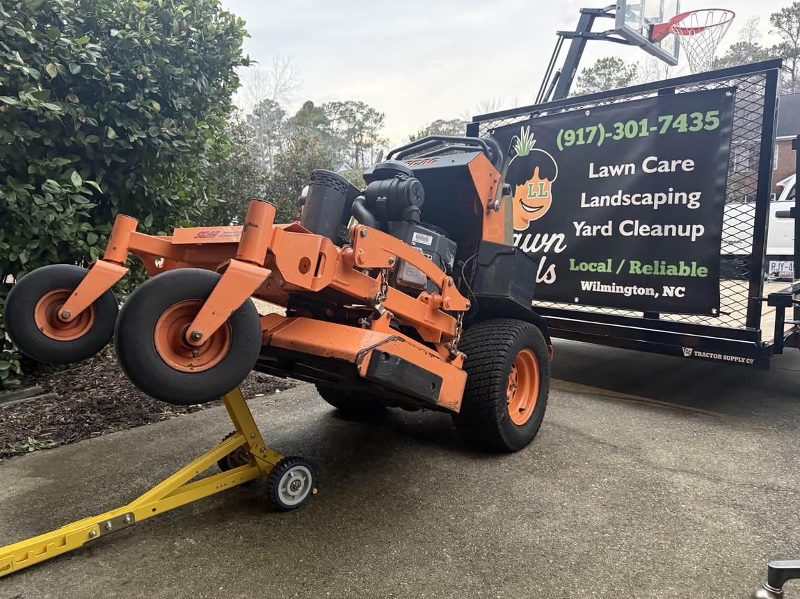 A Scag stand-on loading onto the branded Lawn Lads trailer