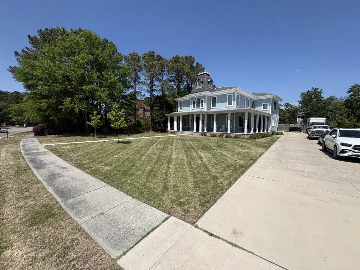 Striped lawn in front of a white colonial home in Wilmington